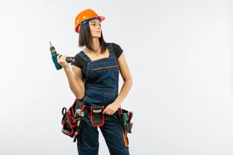 Young woman with toolbelt using driil and some power tools for her work at ho Stock Photos