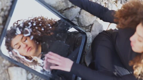 Young woman touching her reflection in a mirror outdoors Stock Footage 332949294