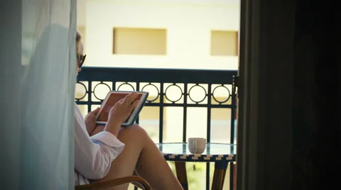 Young woman with touchpad on hotel balcony Stock Footage