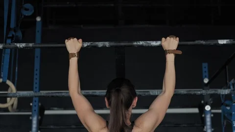 Young woman training pull ups exercise enjoying intense fitness workout in gym Stock Footage