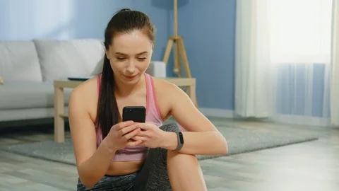 Young Woman Is Training Using Mobile Fitness Application Stock Footage 129748491