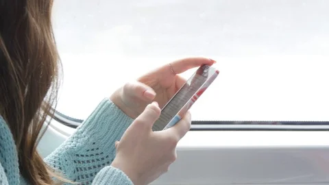 Young woman traveling in a train and using mobile phone. Female hand sends a Stock Footage