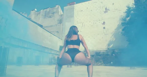 Young woman twerking outdoors in blue sm... | Stock Video