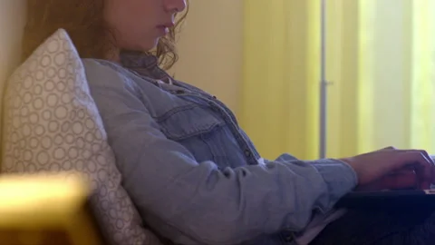 Young woman types on laptop while sits on bed in hotel room Stock Footage 239435367