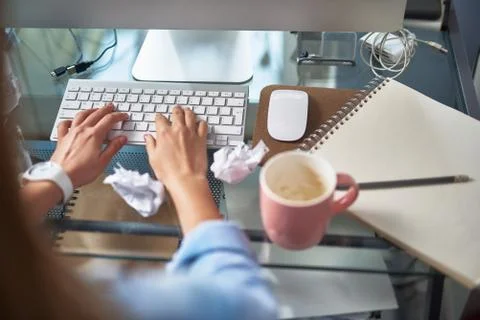 Young woman typing on computer while working at home Stock Photos