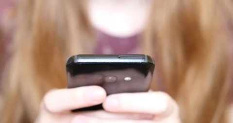 Young woman typing message on a smartphone Stock Footage