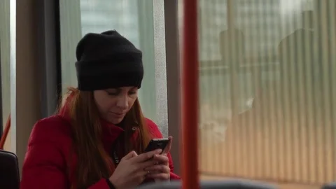 Young woman typing message using mobile phone during evening ride in the bus Stock Footage 83610149