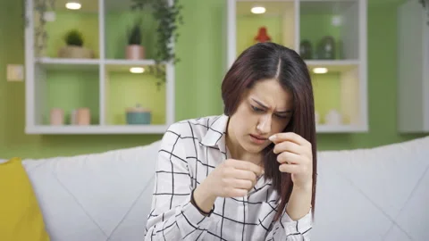Young woman upset about split ends. Stock Footage 237334886