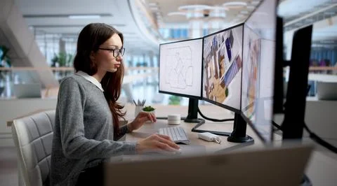Young Woman Uses Computer To Explore Virtual Interior Remodel Options. 库存照片