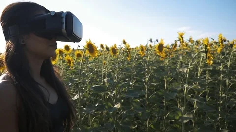 Young woman uses head-mounted display outdoor. Playing game using VR-helmet for Stock Footage