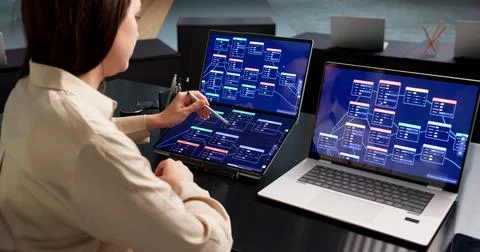 Young Woman Uses Low Code Tools On Laptop To Design Workflow Automation. Stock Photos