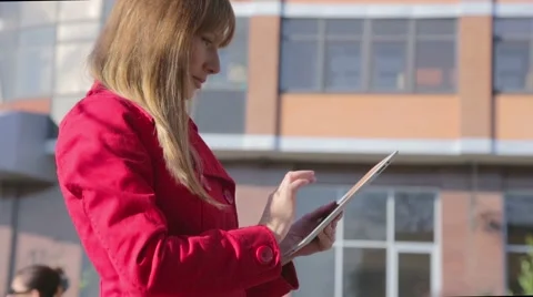 Young woman uses tablet computer outdoor Stock Footage 43833747
