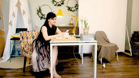 Young woman uses a tablet while relaxing at home at the table 库存影片 127615354