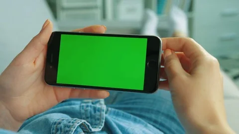 Young woman using black smart phone with green screen. Woman holding mobile Stock Footage