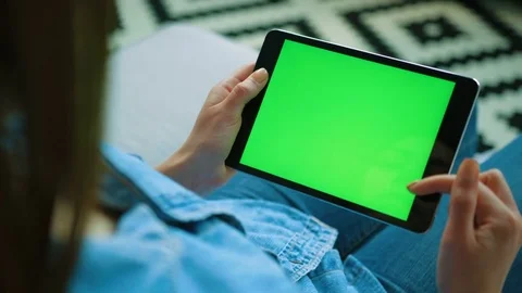 Young woman using black tablet device with green screen. Woman holding tablet Stock Footage 76375923
