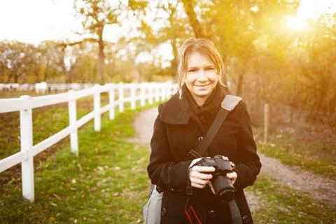 Young woman using a camera to take photo outdoor. Stock Photos