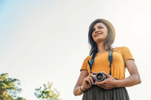 Young woman using a camera to take photo. Stock Photos