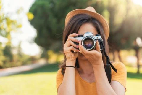 Young woman using a camera to take photo. Stock Photos