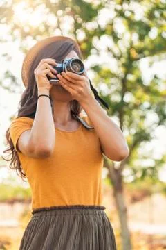 Young woman using a camera to take photo. Stock Photos