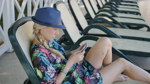 Young woman using cellphone while lying on sunbed at hotel Video stock 68666411