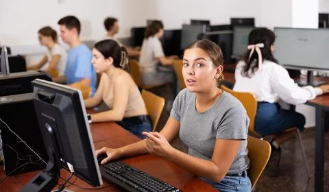 Young woman using computer in classroom, pointing on monitor 写真素材
