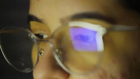 Young woman using computer at night, screen reflection in glasses Stock Footage 320536340