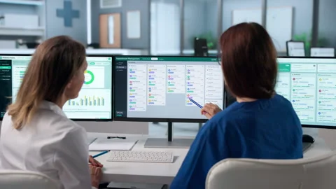 Young Woman Using Computer To Organize Patient Appointments Stock Footage 343891386