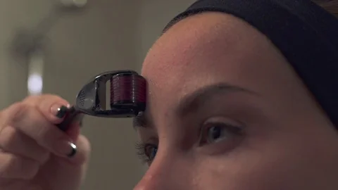 Young woman using a derma roller for micro needling therapy face Stock Footage 78499588