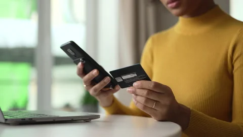 Young woman using devices and credit card for online shopping and sitting at Stock-Footage 172480976