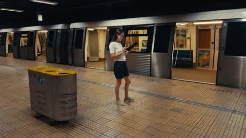Young woman using digital map on smartphone while standing at subway station Video stock 315429964