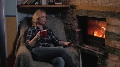 Young Woman Using Digital Tablet PC And Enjoying Winter Hot Drink Sitting By Stock Footage 72139490