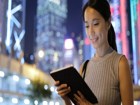 Young woman using digital tablet in Hong Kong at night Vídeos de archivo 80179639