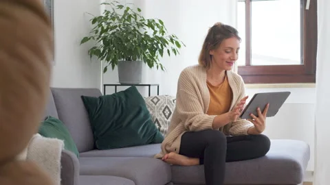 Young woman using digital tablet in living room for videochat Stock Footage 136167671
