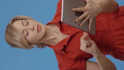 Young woman using digital tablet, blue background. Stock Footage 152019923