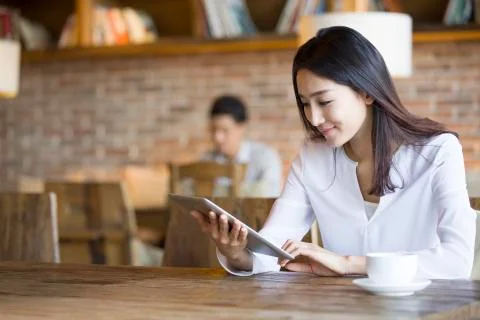 Young woman using digital tablet in cafe Stock Photos