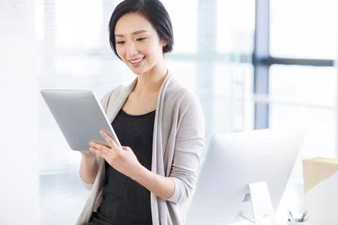 Young woman using digital tablet in office Stock Photos