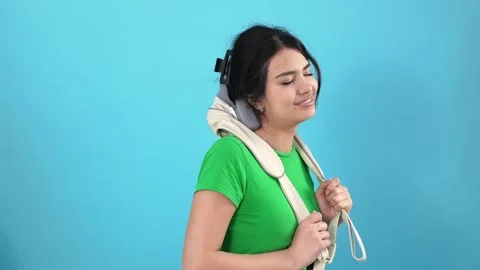 Young Woman Using Electric Neck Massager for Shoulder Muscle Relief on Blue.. Stockbeeldmateriaal 346111325