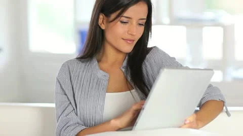 Young woman using electronic tablet sitting in sofa Stock Footage 14828243