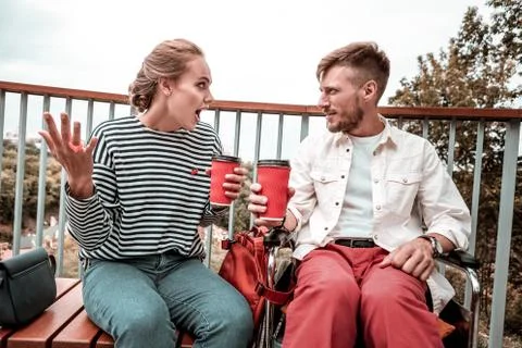 Young woman using gestures while talking to her attentive friend Stock Photos