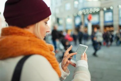 Young woman using GPS on smart phone on urban street Stock Photos