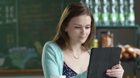 Young woman using an ipad/tablet in a cafe setting Stock Footage