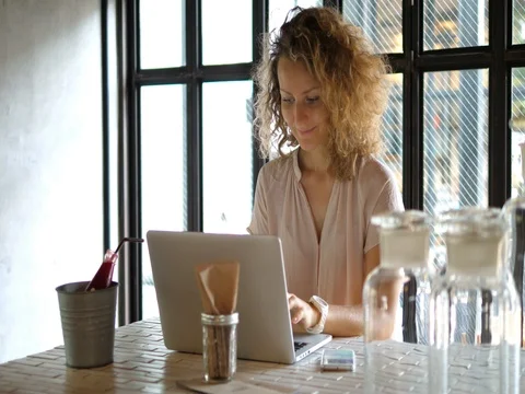 Young Woman Using Laptop Computer And Mobile Phone In Cafe. 4K. Stockbeeldmateriaal 78480398