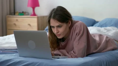 Young woman using a laptop computer on bed Stock Footage 237627377