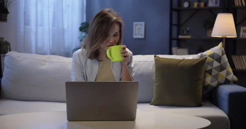 Young woman using laptop computer browsing through websites, watching video Stock Footage 262657727