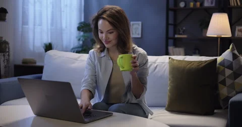 Young woman using laptop computer browsing through websites, watching video Vidéo 263157151