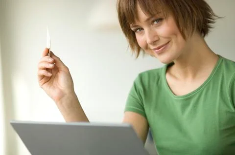 Young woman using laptop computer, smiling for the camera Foto stock