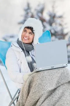 Young woman using laptop computer in snow Stock Photos