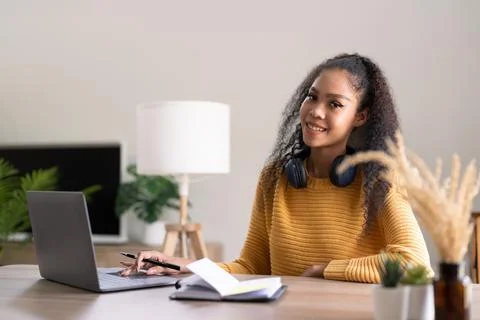 Young woman using laptop computer at office. Student girl working at home. Work Stock Photos