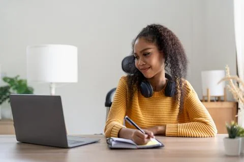 Young woman using laptop computer at office. Student girl working at home. Work Stock Photos