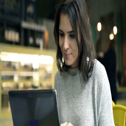 Young woman using laptop while sitting in cafe. 4K Stock Footage 69512815
